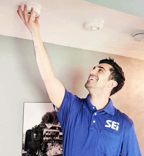 Technician installing fire alarm for a monitored fire alarm.