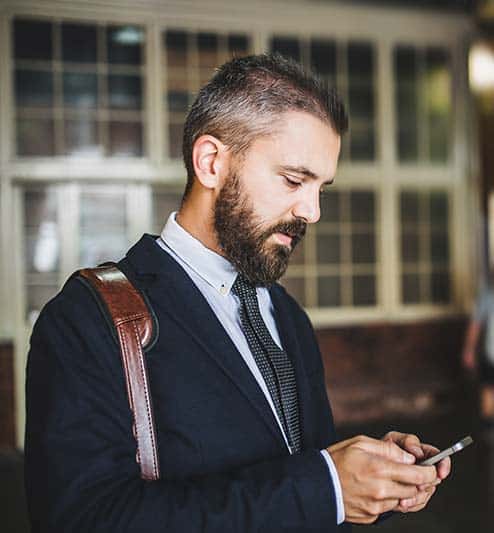 Man looking at cell phone application to control home automation services