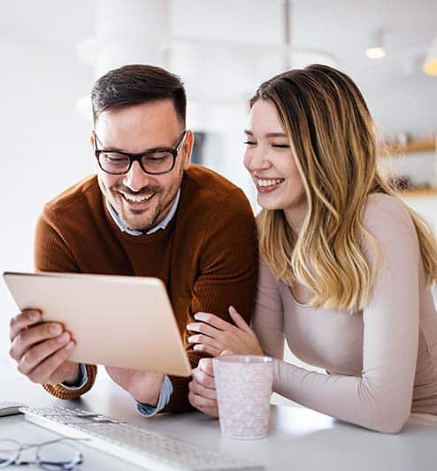 Couple in a kitchen using a tablet to set up connected home services