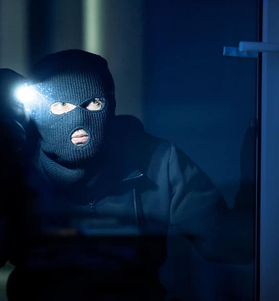Burglar in mask breaking in
