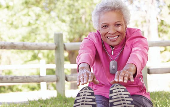 senior woman exercising with a medical alert device pendant