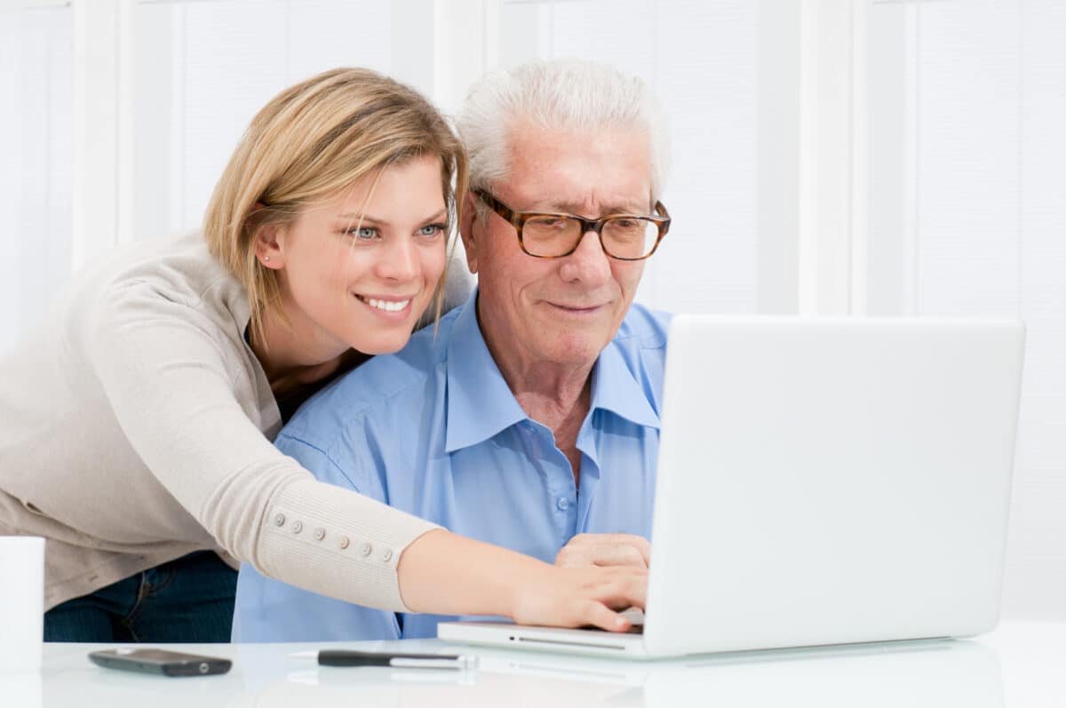 a daughter helps her elderly housebound father on his laptop create a security and safety plan